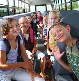 Students pose on a school bus